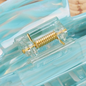 Macro shot of 14cm acetate hair claw with high-elastic gold metal spring and marble texture