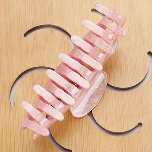 Detail view of pink glitter acrylic hair claw clip for thick hair styling