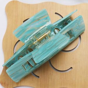 Detail of 14cm large acetate hair claw clip with green marble texture and gold spring