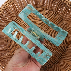 Detail of a large mint marble acetate hair claw with a gold spring for thick hair