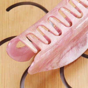 Close-up of pink marble acrylic hair claw clip with golden glitter and smooth teeth