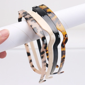 Détail de serre-têtes antidérapants ondulés en couleurs écaille, noir et beige