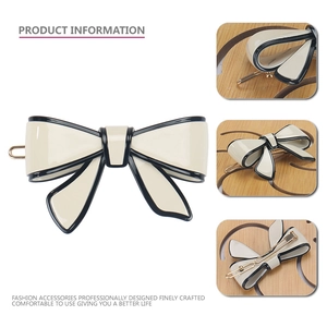 Elegant cream bow hair clip with black trim and gold spring metal fastening