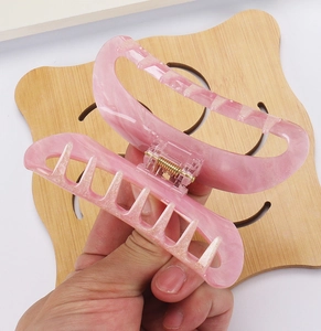 Detail view of pink marble texture hair claw clip with golden glitter and strong metal spring