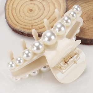 Close-up of cream acetate hair claw clip featuring elegant gradient white pearls
