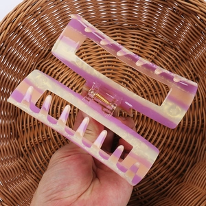 Detail of a large 11cm gradient acetate hair claw clip with purple and orange pearlescent finish