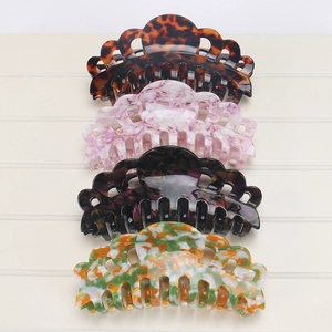 Detail of four extra large acetate hair claws in various floral and marble patterns