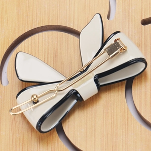 Macro shot of the bow hair clip golden metal clip mechanism on cream acetate