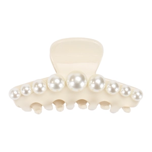 Detail view of cream acetate hair claw clip with symmetric white faux pearls on white base