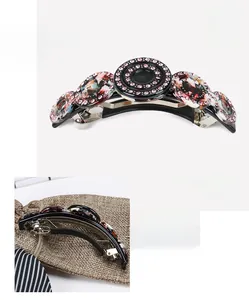 Detail view of acetate barrette with pink rhinestones and a black enamel center
