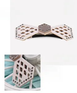 Detailed view of pink cellulose acetate hair clip with rhinestones and hollow grid pattern