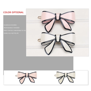 Classic acetate bow hair clips in pink and cream white with elegant black trim