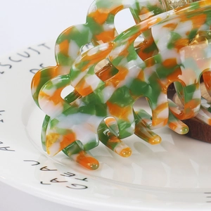 Close-up of a 14cm large acetate hair claw clip with colorful floral marble patterns