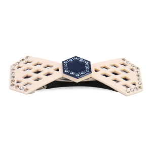 Detailed macro shot of beige and blue bow hair clip with rhinestone inlays