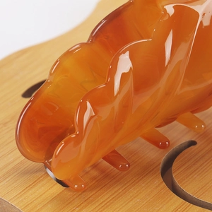 Macro shot of polished amber acetate hair claw clip showing smooth wave design and teeth