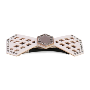 Macro detail of beige hollow acetate hair clip with sparkling rhinestone edge embellishment