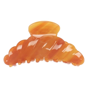 Close-up of amber orange acetate hair claw clip with elegant marble texture and teeth