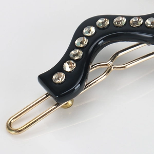 Détail macro de la barrette à cheveux ondulée noire en acétate avec neuf strass