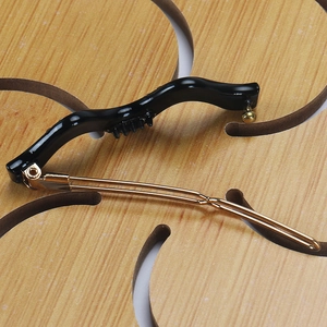 Détail macro de la pince à cheveux en résine noire avec broche dorée et dents antidérapantes