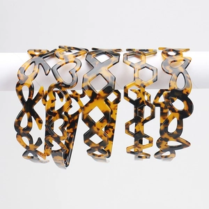 Detail showing five tortoiseshell acetate headbands with geometric hollow patterns