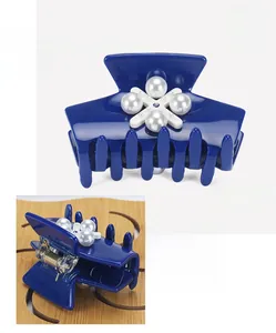 Détail de la pince à cheveux en acétate bleu avec perles en croix et strass brillant