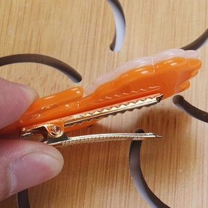 Détail de la pince à cheveux en métal doré avec un design de fixation dentelé sécurisé