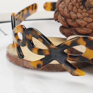Close-up of tortoise shell pattern headband with elegant hollow butterfly knot detail