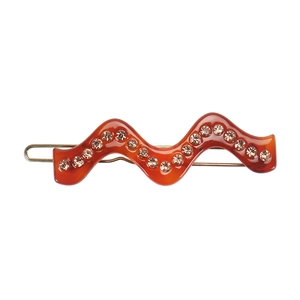 Détail de la barrette en résine ambrée au design ondulé et strass scintillants
