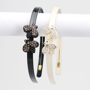 Detail of French acetate headband with sparkling rhinestone bee motif in black and beige