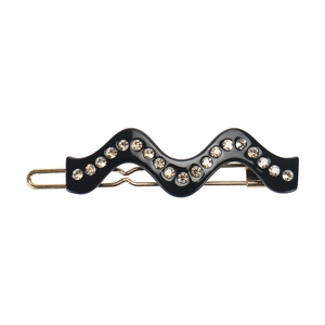 Détail d'une pince à cheveux ondulée noire en acétate avec strass et base en métal doré