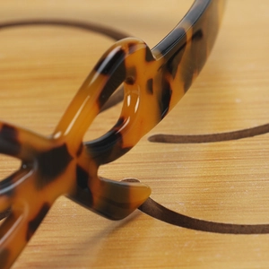 Macro view of polished tortoise shell acetate headband showing cutout details and texture
