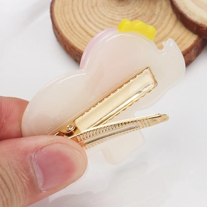 Détail de la pince à cheveux avec mécanisme en métal dentelé et dessus en acétate de dessin