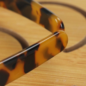 Macro shot of tortoiseshell pattern finish and smooth edge detail on premium acetate headband