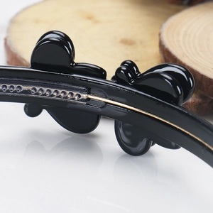 Detail view of black double-layered headband with butterfly clips and non-slip teeth