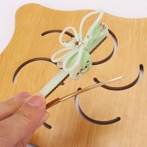 Détail d'une pince à cheveux papillon en acétate avec strass et épingle dorée