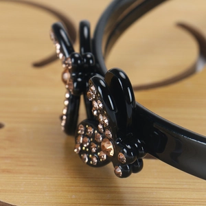 Macro detail of French bee style headband featuring champagne rhinestone mickey decoration