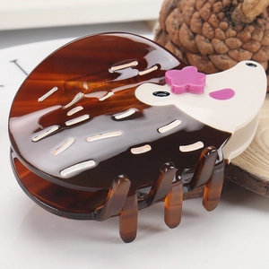 Détail de la pince à cheveux hérisson avec texture écaille de tortue et fleurs violettes
