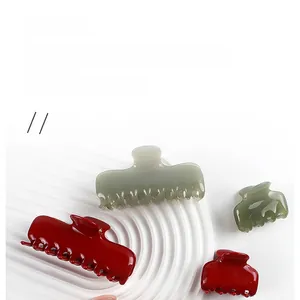 Detalle de pinzas para el cabello en acetato brillante rojo y gris-verde en dos tamaños