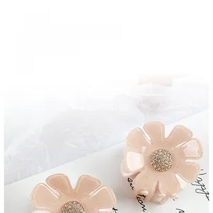 Detail von rosa Acetat-Blumen-Haarspangen mit Goldglitzer und funkelnden Strasssteinen