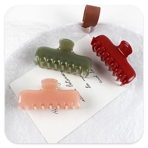 Detalle de pinzas para el cabello en verde oscuro, rosa nude y rojo vintage translúcido