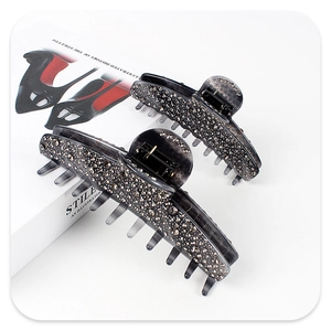 Close-up of smoke grey acetate hair claws with sparkling rhinestones and metal spring