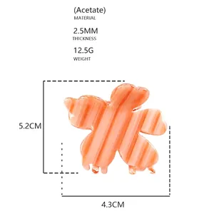 Detailansicht der kleinen Acetat-Blumen-Haarklammer mit orangefarbenen Streifen, 5,2 cm