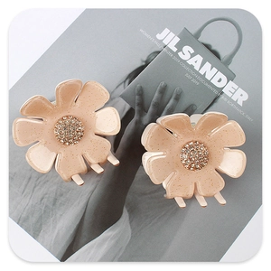 Detailaufnahme der rosa Blumen-Haarklammern mit Glitzer-Finish und Strass-Zentrum