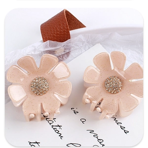 Makro-Detail von Blumen-Haarklammern aus Acetat mit Goldglitzer und Kristall-Strasssteinen