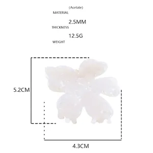 Makro-Detail der Haarspange aus weißem Acetat mit Streifenmuster und Metallfeder