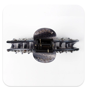 Detail of smoky grey acetate shark hair claw clip with rhinestones and leopard pattern