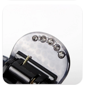 Macro shot of smoky grey acetate hair claw clip with five sparkling white rhinestones