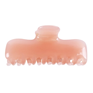 Detalle de una pinza para el cabello de acetato rosa gelatina con textura jaspeada