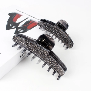 Smoky grey acetate hair claw clips with rhinestones set on a fashion magazine