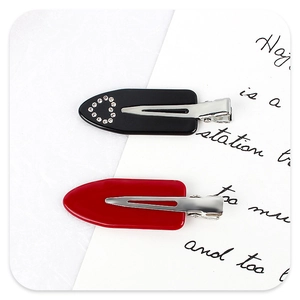 Lot de barrettes avec cœur en strass noir et pince rouge unie sur une carte décorative